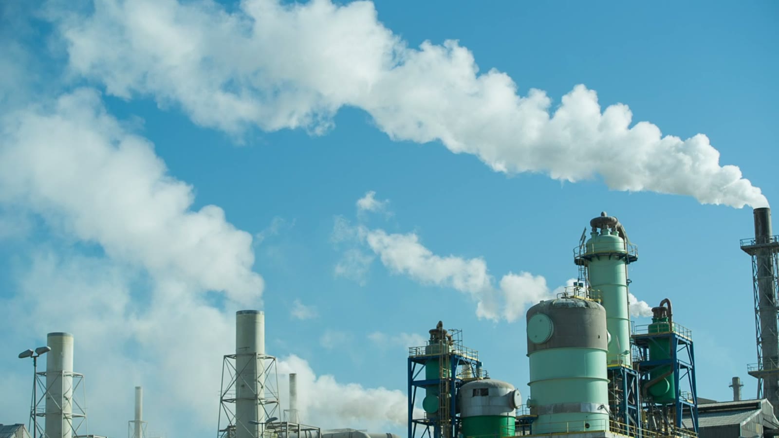 Towers and steam lines of an industrial plant.